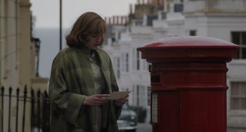 Movie still from “My Policeman” (2022), directed by Michael Grandage – A woman standing in front of a red mailbox; Medium shot, Low angle
