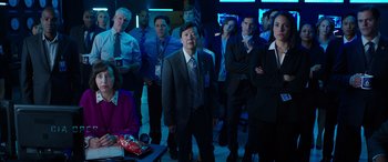 Movie still from “My Spy” (2020), directed by Peter Segal – A group of people standing in a dark room; Wide shot, Over the shoulder angle