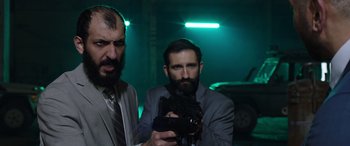 Movie still from “My Spy” (2020), directed by Peter Segal – Two men in suits and ties holding a video camera; Medium shot, Low angle