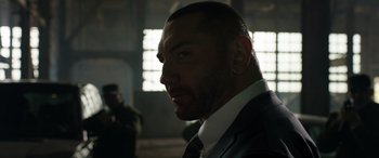 Movie still from “My Spy” (2020), directed by Peter Segal – A person wearing a suit and tie; Close Up shot, Low angle