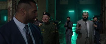 Movie still from “My Spy” (2020), directed by Peter Segal – A group of men standing next to each other in the dark; Medium shot, Over the shoulder angle