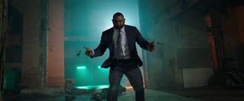 Movie still from “My Spy” (2020), directed by Peter Segal – A man in a suit and tie standing in the middle of an alley; Wide shot, Low angle