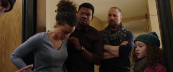 Movie still from “My Spy” (2020), directed by Peter Segal – A group of people standing around each other in a room; Medium shot, Over the shoulder angle