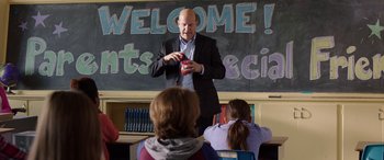 Movie still from “My Spy” (2020), directed by Peter Segal – A man in a suit is giving a lecture to a class; Medium shot, Over the shoulder angle