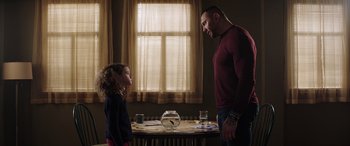 Movie still from “My Spy” (2020), directed by Peter Segal – A man and a little girl standing in front of a fish bowl; Medium shot, Over the shoulder angle