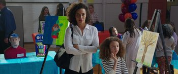 Movie still from “My Spy” (2020), directed by Peter Segal – A woman standing next to a young girl in front of balloons; Medium shot, Over the shoulder angle