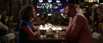 Movie still from “My Spy” (2020), directed by Peter Segal – A man and a woman sitting at a table with wine glasses; Medium shot, Over the shoulder angle