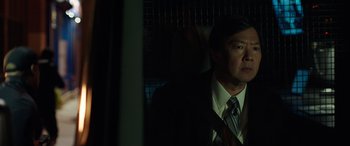 Movie still from “My Spy” (2020), directed by Peter Segal – A man wearing a suit and tie standing in front of a window; Close Up shot, Over the shoulder angle