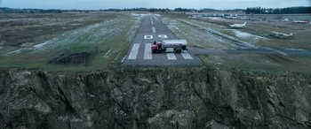 Movie still from “My Spy” (2020), directed by Peter Segal – An aerial view of an airport runway with a truck on it; Extreme Wide shot, High angle
