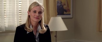 Movie still from “National Treasure” (2004), directed by Jon Turteltaub – A woman in a black jacket is smiling for the camera; Close Up shot, Over the shoulder angle