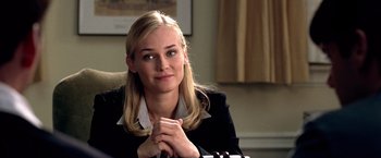 Movie still from “National Treasure” (2004), directed by Jon Turteltaub – A woman sitting at a table with her hands clasped together; Close Up shot, Over the shoulder angle
