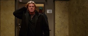 Movie still from “National Treasure” (2004), directed by Jon Turteltaub – A man with blonde long hair is walking down a hallway; Medium shot, Low angle
