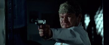 Movie still from “National Treasure” (2004), directed by Jon Turteltaub – A man with a bandana on his head is holding a gun; Close Up shot, Low angle