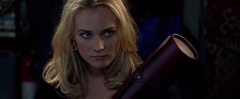 Movie still from “National Treasure” (2004), directed by Jon Turteltaub – A beautiful blonde woman holding a gun in a dark room; Close Up shot, Over the shoulder angle