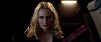 Movie still from “National Treasure” (2004), directed by Jon Turteltaub – A woman with long blonde hair is posing for the camera; Close Up shot, Over the shoulder angle