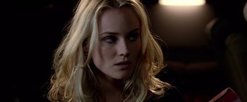 Movie still from “National Treasure” (2004), directed by Jon Turteltaub – A woman with blonde hair and blue eyes looking at the camera; Close Up shot, Over the shoulder angle