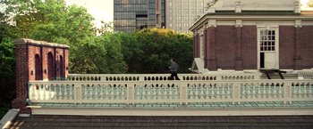Movie still from “National Treasure” (2004), directed by Jon Turteltaub – A man walking across a bridge near a building; Extreme Wide shot, High angle