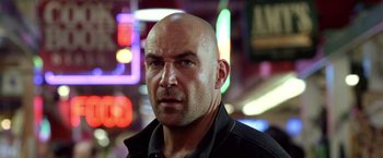 Movie still from “National Treasure” (2004), directed by Jon Turteltaub – A man with bald head looking at the camera; Close Up shot, Low angle