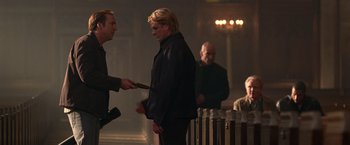 Movie still from “National Treasure” (2004), directed by Jon Turteltaub – A man in a black jacket is holding a wooden stick; Medium shot, Over the shoulder angle