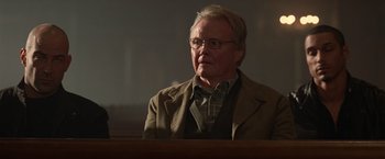 Movie still from “National Treasure” (2004), directed by Jon Turteltaub – An older man sitting in front of a wooden table; Close Up shot, Low angle