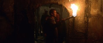 Movie still from “National Treasure” (2004), directed by Jon Turteltaub – A group of people standing around a fire; Medium shot, Over the shoulder angle