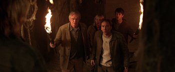 Movie still from “National Treasure” (2004), directed by Jon Turteltaub – A group of people standing next to each other holding torches; Medium shot, High angle