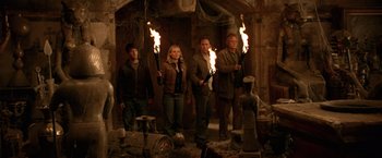 Movie still from “National Treasure” (2004), directed by Jon Turteltaub – A group of people holding torches in a room; Wide shot, High angle