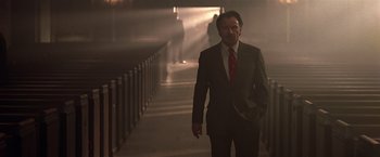 Movie still from “National Treasure” (2004), directed by Jon Turteltaub – A man wearing a suit and tie walking down a staircase; Medium shot, Low angle