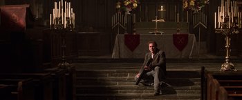 Movie still from “National Treasure” (2004), directed by Jon Turteltaub – A man sitting on some steps in a church; Wide shot, Low angle