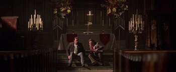 Movie still from “National Treasure” (2004), directed by Jon Turteltaub – A couple of men sitting next to each other on some steps; Wide shot, Low angle