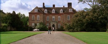 Movie still from “National Treasure” (2004), directed by Jon Turteltaub – Two people standing in front of a large brick building; Extreme Wide shot, Low angle
