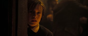 Movie still from “National Treasure: Book of Secrets” (2007), directed by Jon Turteltaub – A young boy is looking at the camera in the dark; Close Up shot, Low angle