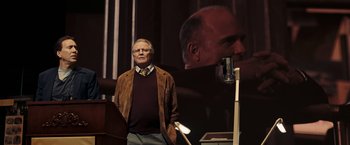 Movie still from “National Treasure: Book of Secrets” (2007), directed by Jon Turteltaub – An older man standing in front of a microphone; Medium shot, Low angle