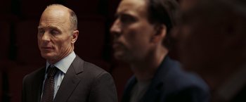 Movie still from “National Treasure: Book of Secrets” (2007), directed by Jon Turteltaub – Two men in business suits standing next to each other; Close Up shot, Over the shoulder angle