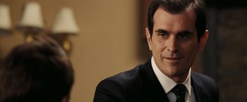 Movie still from “National Treasure: Book of Secrets” (2007), directed by Jon Turteltaub – A person wearing a suit and tie; Close Up shot, Over the shoulder angle