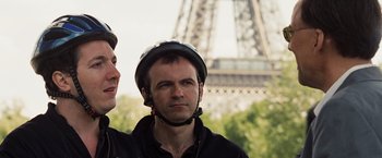 Movie still from “National Treasure: Book of Secrets” (2007), directed by Jon Turteltaub – A man wearing a bicycle helmet in front of the eiffel tower; Close Up shot, Low angle