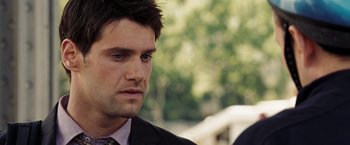 Movie still from “National Treasure: Book of Secrets” (2007), directed by Jon Turteltaub – A person wearing a suit and tie; Close Up shot, Over the shoulder angle