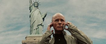 Movie still from “National Treasure: Book of Secrets” (2007), directed by Jon Turteltaub – An older man is holding his hands up to his ears; Close Up shot, Low angle