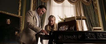 Movie still from “National Treasure: Book of Secrets” (2007), directed by Jon Turteltaub – A man and a woman are looking at something on a table; Medium shot, Low angle