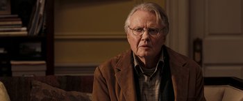 Movie still from “National Treasure: Book of Secrets” (2007), directed by Jon Turteltaub – An older man wearing glasses and a brown jacket; Close Up shot, Over the shoulder angle