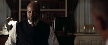 Movie still from “National Treasure: Book of Secrets” (2007), directed by Jon Turteltaub – A man sitting in front of a computer in a room; Medium shot, Low angle