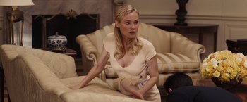 Movie still from “National Treasure: Book of Secrets” (2007), directed by Jon Turteltaub – A beautiful blonde woman holding a card in a room; Medium shot, Over the shoulder angle