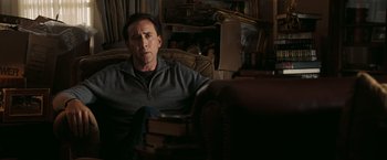 Movie still from “National Treasure: Book of Secrets” (2007), directed by Jon Turteltaub – A man sitting on a couch in a living room; Medium shot, Low angle