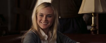 Movie still from “National Treasure: Book of Secrets” (2007), directed by Jon Turteltaub – A woman smiles for a picture while wearing a white shirt; Close Up shot, Over the shoulder angle