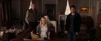 Movie still from “National Treasure: Book of Secrets” (2007), directed by Jon Turteltaub – A woman sitting on a chair in front of two men; Medium shot, High angle