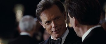 Movie still from “National Treasure: Book of Secrets” (2007), directed by Jon Turteltaub – A person wearing a suit and tie; Close Up shot, Over the shoulder angle