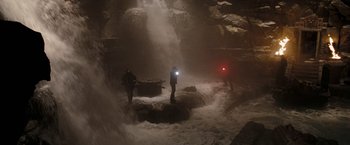 Movie still from “National Treasure: Book of Secrets” (2007), directed by Jon Turteltaub – Two people are standing in a cave under a waterfall; Extreme Wide shot, High angle
