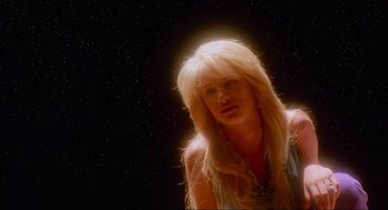 Movie still from “Natural Born Killers” (1994), directed by Oliver Stone – A woman with long blonde hair is looking at the camera; Close Up shot, Low angle