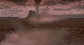 Movie still from “Natural Born Killers” (1994), directed by Oliver Stone – An image of a tornado coming out of the ground; Extreme Wide shot, Low angle