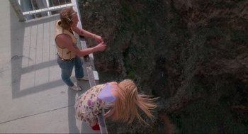 Movie still from “Natural Born Killers” (1994), directed by Oliver Stone – A woman and a child climbing a ladder to the top of a cliff; Wide shot, Overhead angle